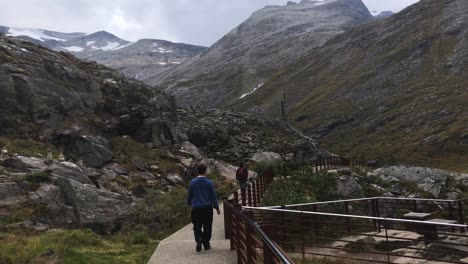 Tourist-walking-over-a-modern-path-created-in-the-mountains-of-Trollstigen-in-slow-motion