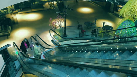 Neugieriges-Altes-Paar,-Das-Auf-Eine-Fahrende-Rolltreppe-Steigt-Und-In-Einem-Einkaufszentrum-In-Stockholm-Umherwandert-Und-Starrt