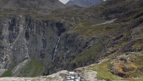 Slow-pan-to-the-right-from-a-couple-of-tourists-to-the-mountains-of-Trollstigen-in-slow-motion