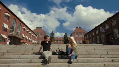Kth-Studenten-Sitzen-Auf-Stufen-In-Der-Nähe-Zweier-Backsteingebäude-Auf-Dem-Stockholmer-Campus