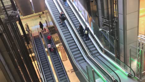 Escalators-and-elevators-at-the-Madrid-Barajas-International-Airport-in-Spain,-travelers-ride-the-escalators-to-get-quicker-to-their-departure-gates-in-the-melty-story-terminal-building