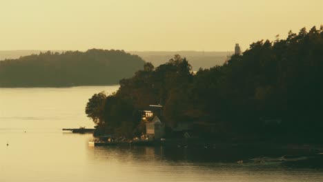 Aerial-view-of-a-home-on-the-water-and-in-the-path-of-sea-cruises-with-rotation-to-show-the-breadth-of-the-archipelago,-filmed-in-UHD-4K