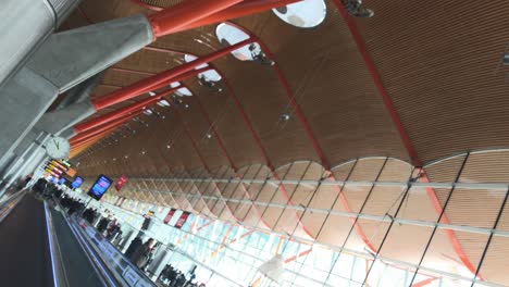 Fahren-Auf-Einem-Express-Gehweg-Im-Modernen-Flughafenterminalgebäude,-Einzigartiges-Design-Und-Architektur-Des-Flughafens-Madrid-Barajas,-Kombination-Von-Holz,-Stahl-Und-Beton,-Niederländischer-Blickwinkel-Mit-Fokus-Auf-Die-Uhr-Am-Ende