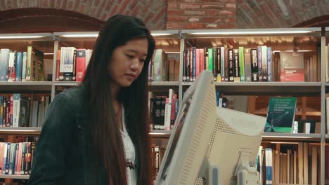 Estudiante-Asiático-Trabajando-En-Una-Computadora-En-La-Biblioteca