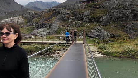 Woman-walking-over-a-modern-bridge-in-the-mountains-of-Trollstigen-in-slow-motion