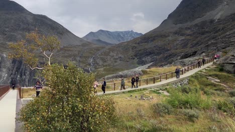 Vista-Panorámica-Desde-El-Lado-Del-Camino-Creado-Sobre-Las-Montañas-De-Trollstigen-Con-Gente-Caminando-En-Cámara-Lenta