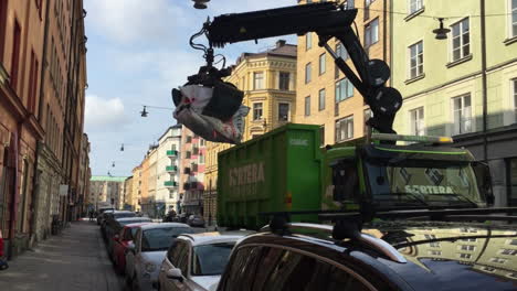 Cleanliness-awareness,-garbage-truck-picking-a-huge-pile-of-trash-on-the-streets-of-Stockholm-Sweden