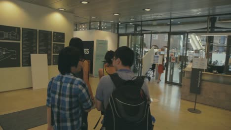 Chinesische-Studenten-Gehen-An-Einem-Mann-Vorbei,-Der-Möbel-Bewegt,-Auf-Die-Universitätsbibliothek-Zu