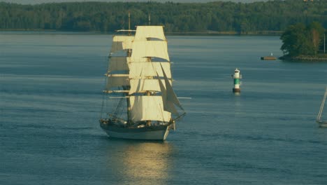 A-large-sailing-ship-with-two-masts-and-multiple-sail-makes-way-through-the-Stockholm-Archipelago