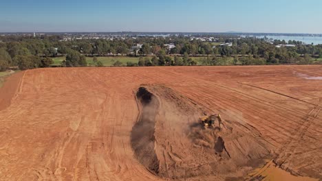 Yarrawonga,-Victoria,-Australia---18-De-Abril-De-2023:-Retroceda-Mostrando-Una-Excavadora-De-Orugas-Trabajando-En-Un-Campo-De-Golf-Con-El-Lago-Y-El-Municipio-De-Yarrawonga-Al-Fondo