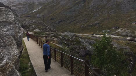 Following-a-man-walking-near-some-rocks-in-Trollstigen-in-slow-motion