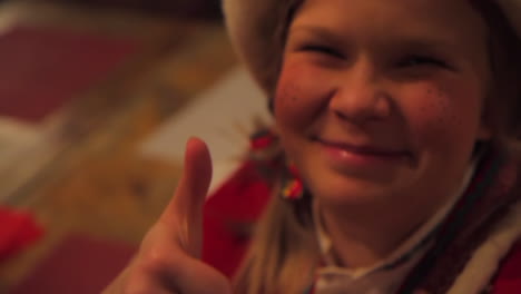 A-young-woman-shows-off-a-decorated-Christmas-cookie,-takes-a-bite,-and-demonstrates-her-satisfaction-with-it