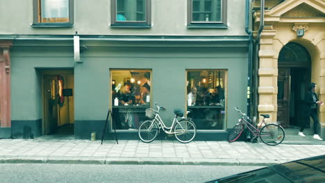 Beautiful-aesthetic-cafe-bar-on-the-streets-of-Stockholm-Sweden-with-bicycles-parked,-wide-shot