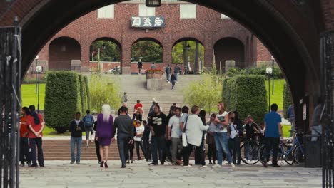 Wide-view-of-people-gathered-under-and-near-an-arched-brick-entryway