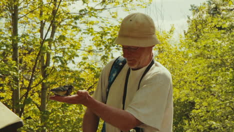 Man-feeding-birds-in-the-palm-of-his-hand