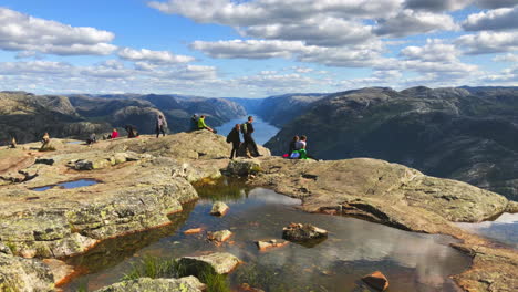 Excursionistas-Turísticos-Relajándose-En-El-Tranquilo-Borde-Superior-De-La-Roca-Del-Púlpito-Preikestolen-En-El-Condado-De-Rogaland,-Noruega
