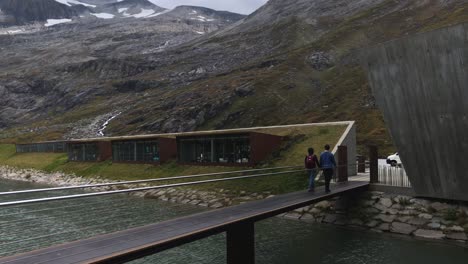 Couple-of-tourists-walking-over-a-bridge-in-Trollstigen-near-the-visitors-center