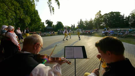 Happy-and-smiling-Scandinavians-demonstrate-the-very-traditional-art-of-folk-dancing-for-a-crowd-of-spectators-as-musicians-play-the-violin