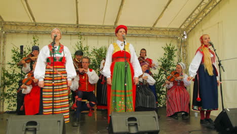 Happy-and-smiling-Scandinavians-demonstrate-the-very-traditional-art-of-folk-dancing-for-a-crowd-of-spectators-as-musicians-play-the-violin