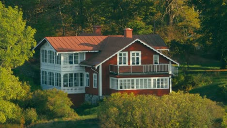 Cineflex-GyroStabilized-Aerial-shot,-around-a-red-and-white-detached-house,-on-a-island,-in-the-Nordic-lakes,at-the-baltic-sea,-on-a-sunny,-summer-day,-near-Stockholm,-Sweden