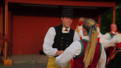 Hermosos-Y-Elegantes-Bailes-Folclóricos-Suecos-Presentados-En-Vivo-En-El-Escenario-En-La-Tradición-De-Celebrar-El-Solsticio-De-Verano-Mientras-Los-Músicos-Tocan-El-Violín.