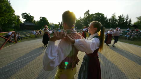Wunderschöner-Und-Anmutiger-Schwedischer-Volkstanz,-Der-In-Der-Tradition-Der-Mittsommerfeier-Live-Auf-Der-Bühne-Präsentiert-Wird,-Während-Musiker-Geige-Spielen
