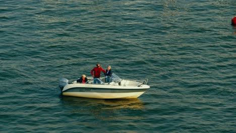 Aerial-view-of-a-moored-small-yacht-with-three-men-on-board
