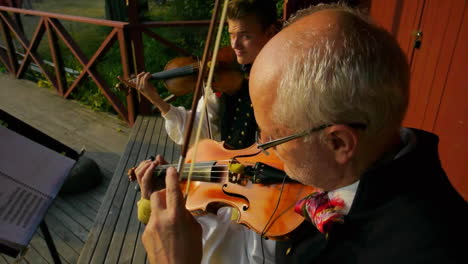 Happy-and-smiling-Scandinavians-demonstrate-the-very-traditional-art-of-folk-dancing-for-a-crowd-of-spectators-as-musicians-play-the-violin