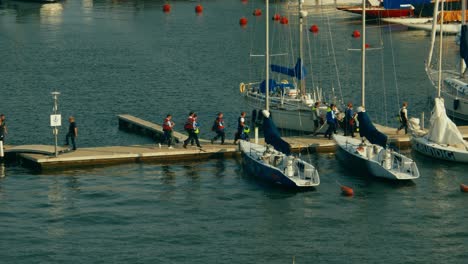 Participants-of-a-regatta-walking-on-a-pier-to-get-on-their-boats-in-slow-motion