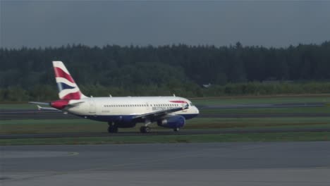 Un-Avión-Rodando-Hacia-La-Pista-Al-Mismo-Tiempo-Que-Un-Avión-Mucho-Más-Grande-Despega-Al-Fondo-En-Estocolmo-Arlanda.