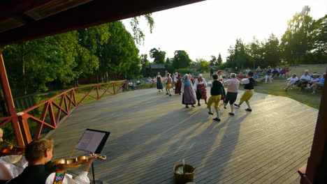 Los-Escandinavos-Felices-Y-Sonrientes-Demuestran-El-Arte-Muy-Tradicional-De-La-Danza-Folclórica-Ante-Una-Multitud-De-Espectadores-Mientras-Los-Músicos-Tocan-El-Violín.