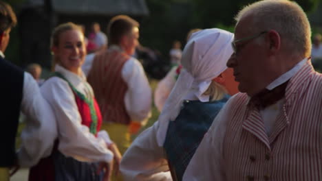 Fröhliche-Und-Lächelnde-Skandinavier-Führen-Einer-Zuschauermenge-Die-Sehr-Traditionelle-Kunst-Des-Volkstanzes-Vor,-Während-Musiker-Geige-Spielen