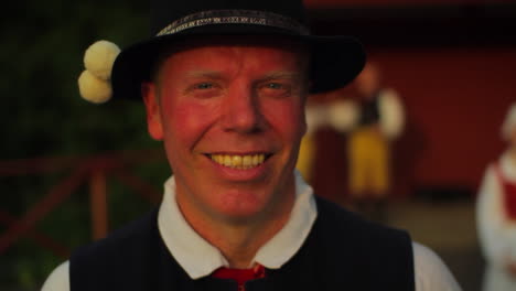 A-beautiful-Swedish-folk-dancer-performer-surrounded-by-fellow-dancers-smiles-at-the-camera-in-the-late-afternoon