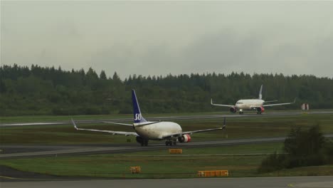 Ein-Flugzeug-Startet,-Während-Ein-Anderes-Flugzeug-Auf-Die-Landebahn-In-Stockholm,-Arlanda,-Zurollt