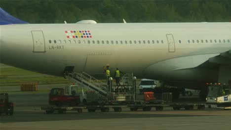 Ground-staff-members-operating-on-a-aircraft,-on-the-runway-of-Stockholm-airport-in-Sweden