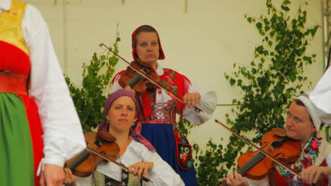 Los-Escandinavos-Felices-Y-Sonrientes-Demuestran-El-Arte-Muy-Tradicional-De-La-Danza-Folclórica-Ante-Una-Multitud-De-Espectadores-Mientras-Los-Músicos-Tocan-El-Violín.