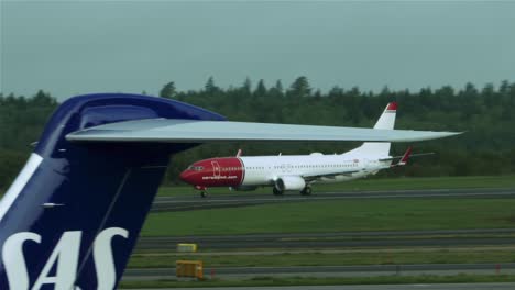 Passagierflugzeug-Bewegt-Sich-Auf-Der-Landebahn,-Vorbei-An-Einer-Flugzeugflotte-Des-Flughafens-Stockholm-In-Schweden