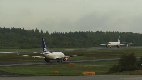 Passagierflugzeuge-Skandinavischer-Fluggesellschaften,-Die-Sich-Auf-Der-Landebahn-Des-Flughafens-Stockholm-In-Schweden-In-Entgegengesetzte-Richtungen-Bewegen