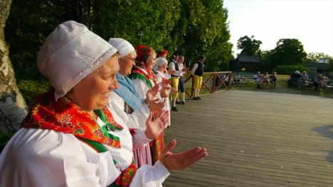 Wunderschöner-Und-Anmutiger-Schwedischer-Volkstanz,-Der-In-Der-Tradition-Der-Mittsommerfeier-Live-Auf-Der-Bühne-Präsentiert-Wird,-Während-Musiker-Geige-Spielen