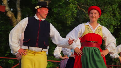 Beautiful-and-graceful-Swedish-folk-dancing-presented-live-on-stage-in-the-tradition-of-celebrating-Midsummer-as-musicians-play-the-violin