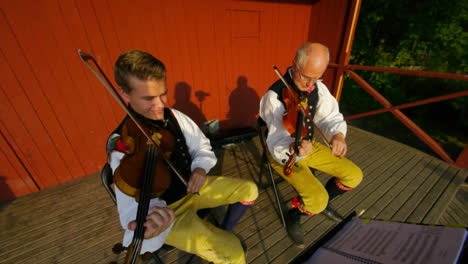 Happy-and-smiling-Scandinavians-demonstrate-the-very-traditional-art-of-folk-dancing-for-a-crowd-of-spectators-as-musicians-play-the-violin