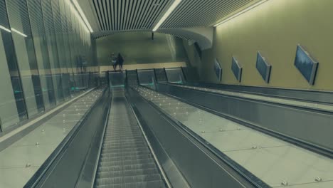 A-MOVING-SHOT-In-An-Downwards-Moving-Escalator-With-Some-People-Stepping-Off-At-The-End-Of-The-Escalator-In-Metro-Of-Stockholm