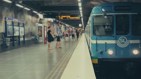 Un-Tren-De-Metro-Que-Llega-A-La-Estación-De-Metro-De-Estocolmo,-Suecia,-Con-Gente-Saliendo-Del-Tren