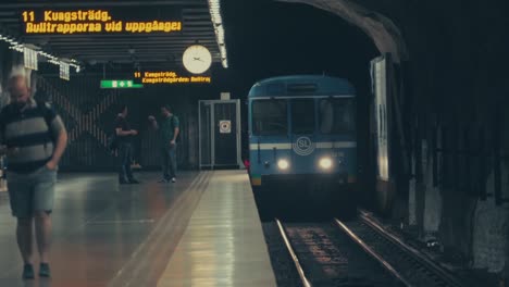 Un-Tren-De-Metro-Que-Llega-A-La-Estación-De-Metro-De-Estocolmo,-Suecia,-Con-Gente-Esperando