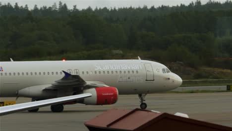 Passenger-aircraft-of-Scandinavian-airlines-turning-on-the-runway-of-Stockholm-airport-in-Sweden,-medium-shot