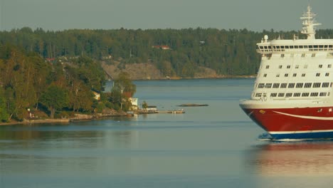 Large-cruise-ferry-MS-Amorella-sailing-through-treacherous-waters-of-the-narrow-channels-in-the-Stockholm-Archipelago,-aerial-drone-high-angle-shot,-ship-approaching-from-ahead