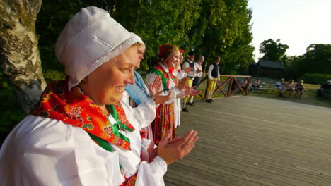 Wunderschöner-Und-Anmutiger-Schwedischer-Volkstanz,-Der-In-Der-Tradition-Der-Mittsommerfeier-Live-Auf-Der-Bühne-Präsentiert-Wird,-Während-Musiker-Geige-Spielen