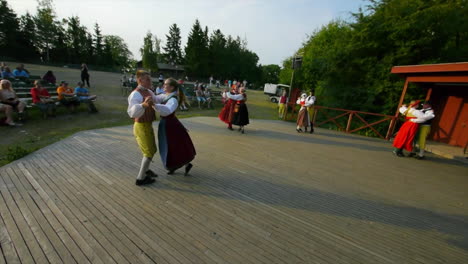 Wunderschöner-Und-Anmutiger-Schwedischer-Volkstanz,-Der-In-Der-Tradition-Der-Mittsommerfeier-Live-Auf-Der-Bühne-Präsentiert-Wird,-Während-Musiker-Geige-Spielen