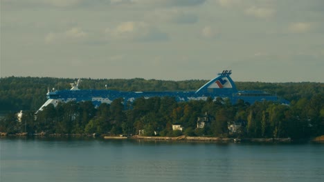 Cineflex-GyroStabilized-Aerial-shot,-around-the-Silja-Line-passenger-ferry,-passing-by-a-island,-in-the-Nordic-lakes,-at-the-baltic-sea,-on-a-sunny,-summer-day,-near-Stockholm,-Sweden