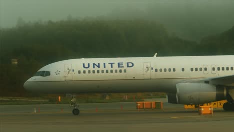 An-airplane-is-taxiing,-from-right-to-left,-towards-the-runway-on-a-foggy-morning-at-Stockholm-Arlanda